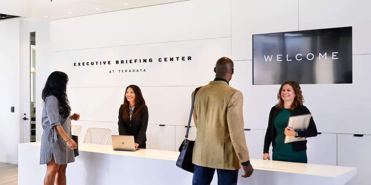 Kunden werden an der Rezeption des Executive Briefing Centers begrüßt.